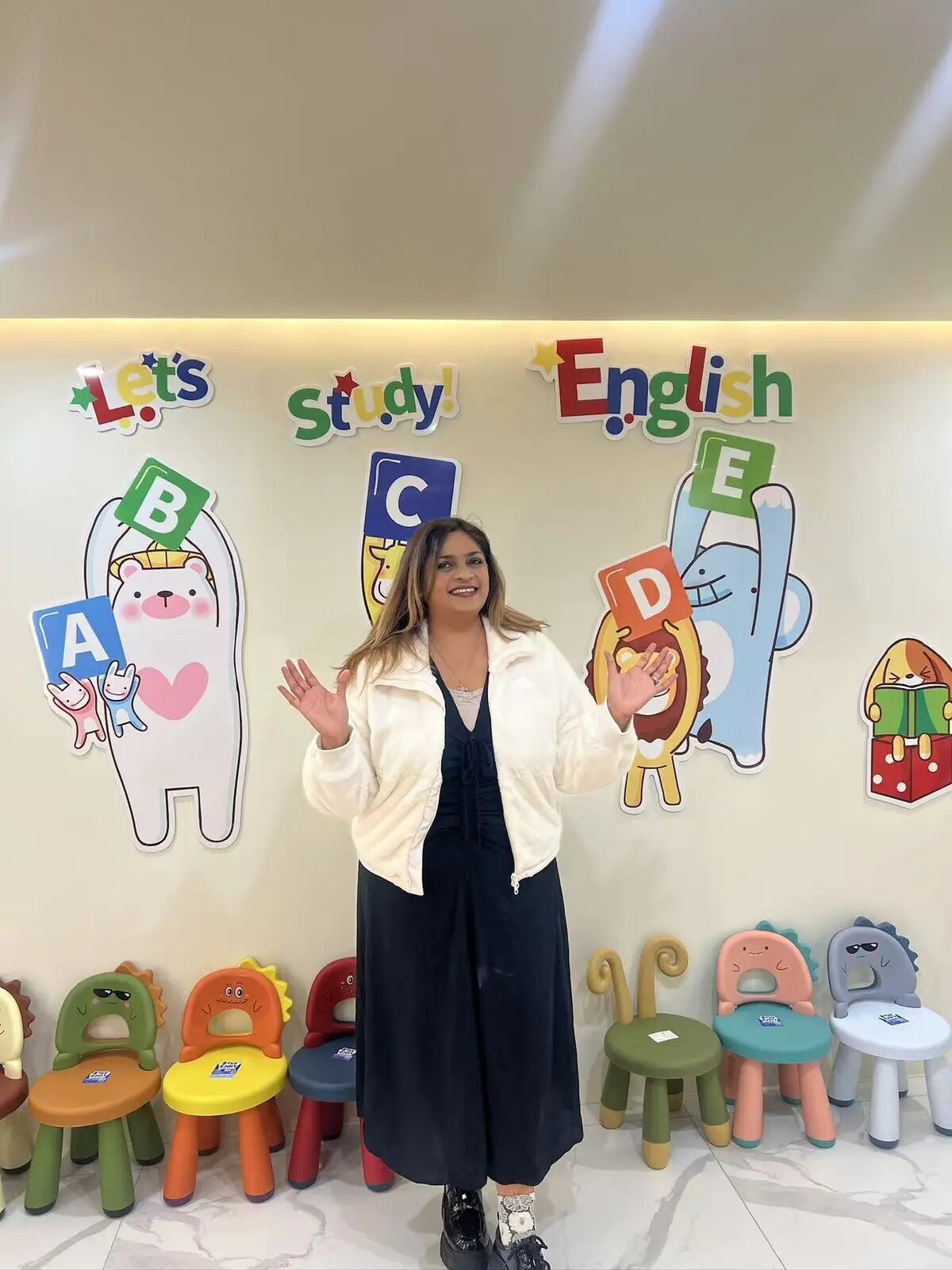Teacher Charmaine welcoming young English learners in a colourful learning space
